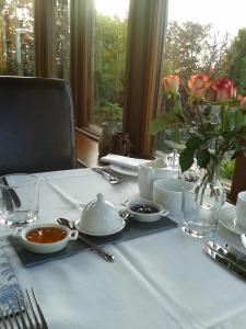 a table with a white table cloth and a vase of flowers at Moor View in Ingleton