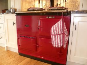 an old red oven with two towels hanging from it at Moor View in Ingleton