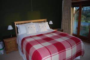 a red and white bed in a room with a window at Moor View in Ingleton 
