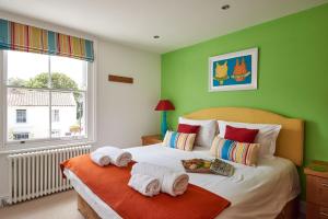 a bedroom with green walls and a bed with towels on it at 252 Aldeburgh Townhouse - Aldeburgh Coastal Cottages in Aldeburgh