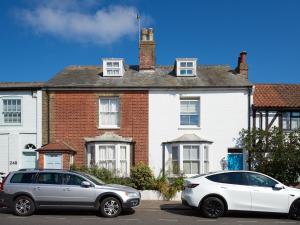 two cars parked in front of a white house at 252 Aldeburgh Townhouse - Aldeburgh Coastal Cottages in Aldeburgh