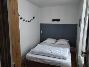 a small bedroom with a bed with white sheets at Maison de village dans une rue calme in Ax-les-Thermes