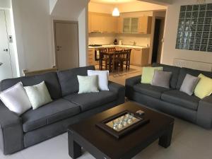 uma sala de estar com um sofá e uma mesa de centro em Porto Rafti Holiday Apartment em Porto Rafti
