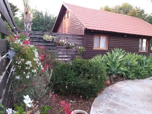 una piccola casa con dei fiori davanti di Tal Nof Cabins a Manot