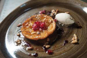 a plate with a doughnut with pomegranates and ice cream at The Canford in Poole