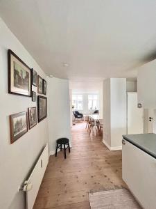 een keuken en eetkamer met witte muren en houten vloeren bij Rebslagerhuset in Ribe