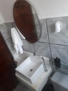 a bathroom with a sink and a mirror at Chalés Alencar in Caraguatatuba