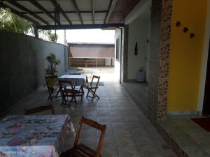 a room with a table and chairs and a patio at Chalés Alencar in Caraguatatuba