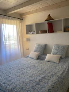 a bedroom with a bed with two pillows and a window at Porto Coda Cavallo in San Teodoro