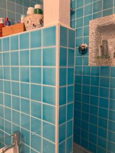 a bathroom with blue tiled walls and a sink at Porto Coda Cavallo in San Teodoro