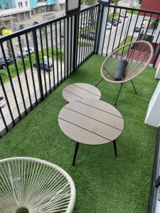 two chairs and a table on a balcony with grass at Marcinkowskiego 11 - 2 in Katowice