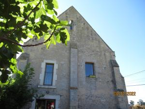 an old stone building with blue windows at Interludes Normands in Ver-sur-Mer
