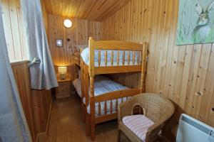 a room with two bunk beds in a cabin at Kelp Cottage in Pollachar
