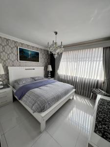 um quarto com uma cama e um lustre em Departamento por Temporadas em La Paz