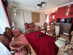 sala de estar con muebles de color rojo y alfombra roja en Departamento por Temporadas, en La Paz