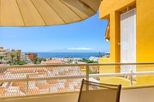 アデへにあるOrlando - Ocean View Apartment in Costa Adejeのバルコニー(椅子、パラソル付)