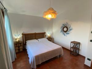 1 dormitorio con 1 cama blanca y 2 mesitas de noche en La Rosa dei Venti en Villaputzu