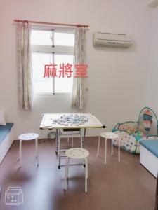 une chambre avec une table, des chaises et une fenêtre dans l'établissement 一見鐘情獨棟包棟民宿, à Wei-ch'ien
