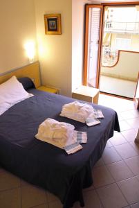 a bedroom with a bed with two towels on it at Grazia Hotel in Sperlonga