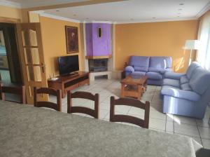 sala de estar con sofá azul y TV en Fuenteazul, en Hortigüela