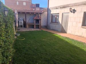 a backyard with a patio with a table and a lawn at Fuenteazul in Hortigüela