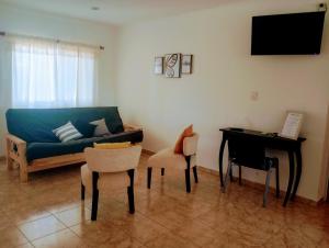 ein Wohnzimmer mit einem blauen Sofa und einem Klavier in der Unterkunft Casa de Juan in Federación