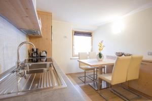 a kitchen with a sink and a table with chairs at Chalet Alaska in Livigno