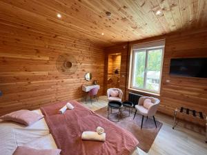 a bedroom with wooden walls and a bed and chairs at Le Clos Joli in Haybes