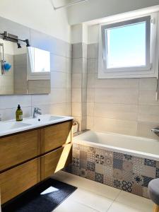 La salle de bains est pourvue d'une baignoire et d'un lavabo. dans l'établissement Beautiful T3 terrasse Nice, à Nice