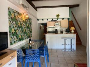a kitchen with a glass table and blue chairs at LES PIEDS DAND L'EAU in Banyuls-sur-Mer