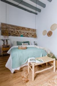 een slaapkamer met een groot bed en een houten bank bij Pitusa Home in Cádiz