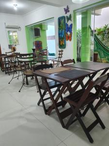 grupa stołów i krzeseł w pokoju w obiekcie Pousada Char w mieście Ubatuba