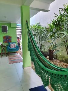 - un hamac au milieu d'une pièce ornée de plantes dans l'établissement Pousada Char, à Ubatuba
