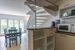 a kitchen with a staircase and a table with a microwave at Superbe appartement en hyper centre, proche plage in Arcachon