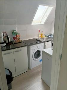 a kitchen with a washing machine and a sink at Cosy village in Bonneuil-en-France