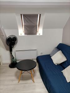 a bedroom with a bed and a table and a window at Cosy village in Bonneuil-en-France