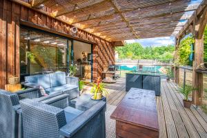 a patio with a couch and a wooden table at Le Hameau de Barbette in Coulounieix-Chamiers