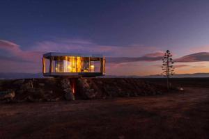a glass house sitting on top of a rock at La Casa del Desierto in Gorafe +20 photos
