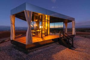 una casa de cristal en la cima de una colina por la noche en La Casa del Desierto, en Gorafe