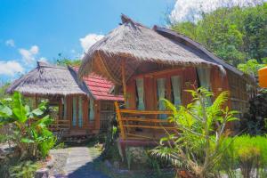 une petite maison avec un toit de paille dans l'établissement The Tamban Jukung, à Nusa Penida