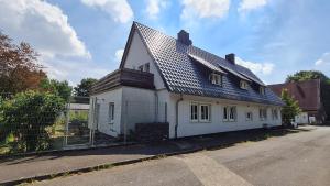 una casa blanca con techo de metal en una calle en Ferienwohnung Ollywood, Natur pur im Westerwald, 2 bis 4 Personen, 