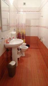bagno con lavandino, servizi igienici e specchio di Casa indipendente Castro a Castro di Lecce