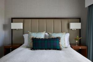 a bedroom with a bed with pillows and two lamps at Marine Troon in Troon