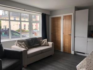 a living room with a couch and a window at 1 bedroom ground floor apartment in Southbourne +10 photos