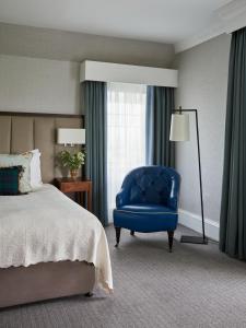 Un dormitorio con una silla azul y una cama en Marine Troon en Troon