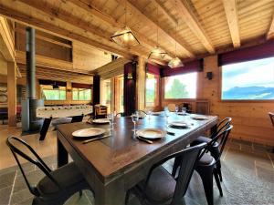 a dining room with a large wooden table and chairs at Superbe chalet avec piscine et hammam à 50m des pistes - FR-1-598-27 in Les Gets