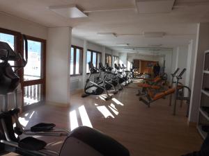 a gym with a row of treadmills and exercise bikes at Guzet Neige 1400 in Ustou