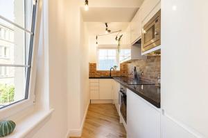a kitchen with white cabinets and a counter top at Central, Bright 2 Bed Flat - Pool & Sauna in Edinburgh