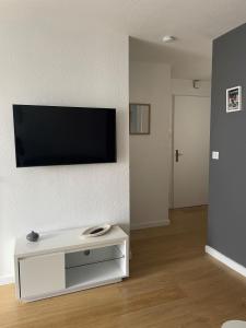 salon z telewizorem z płaskim ekranem na ścianie w obiekcie Appartement T2 de charme les minimes w La Rochelle