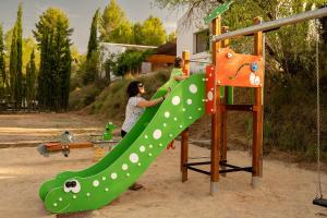 two people playing on a slide at a playground at Slow Life Camping Venta del Moro in Venta del Moro +47 photos
